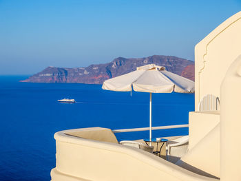 Scenic view of sea and mountains against clear blue sky