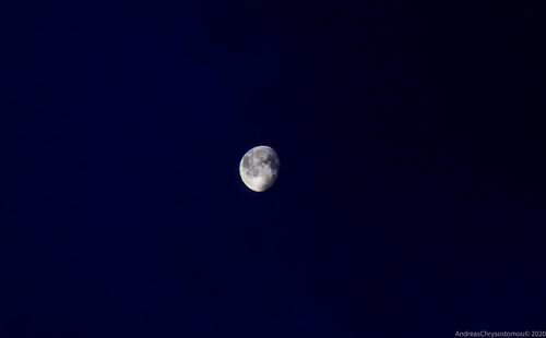 Low angle view of moon against clear blue sky