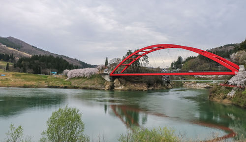 View of bridge over river against cloudy sky