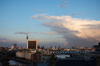 View of cityscape against cloudy sky