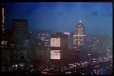 Illuminated cityscape against sky at night