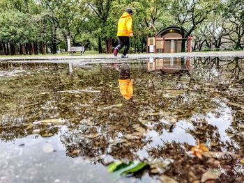 Reflection of boy in water puddle