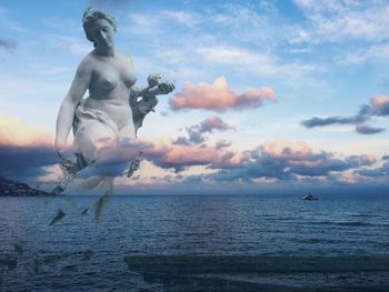 Statue by sea against sky during sunset