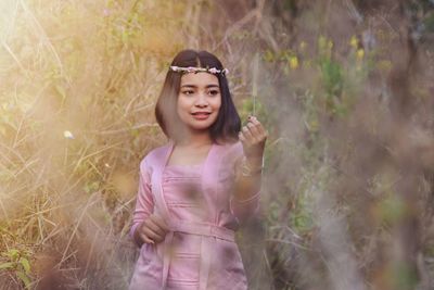 Smiling young woman standing on field