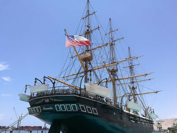 Low angle view of flags against clear blue sky