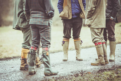 Low section of male friends standing on road