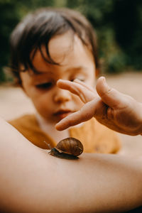 Close-up of hand holding snail