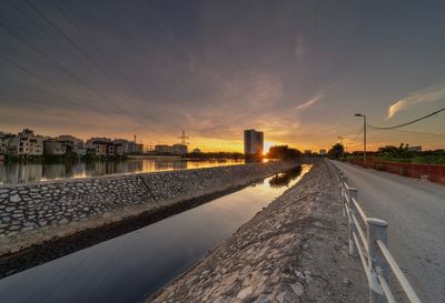 Canal against sky during sunset