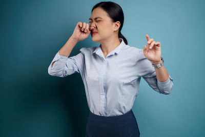 Young woman standing against blue background