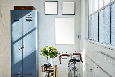 Bicycle by locker against wall at home