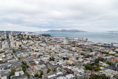 High angle view of townscape by sea against sky