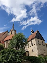 Low angle view of trees and building against sky