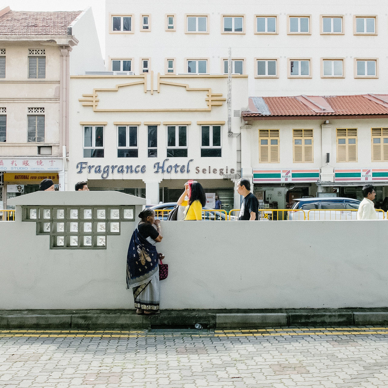 building exterior, architecture, built structure, men, lifestyles, person, city, leisure activity, transportation, building, walking, street, city life, window, sitting, mode of transport, day, bicycle