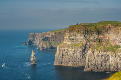 Rock formations by sea against sky