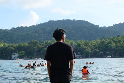 Rear view of woman standing in sea