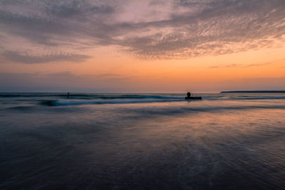 Scenic view of beach against sky during sunset