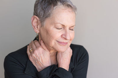 Portrait of smiling woman against gray background