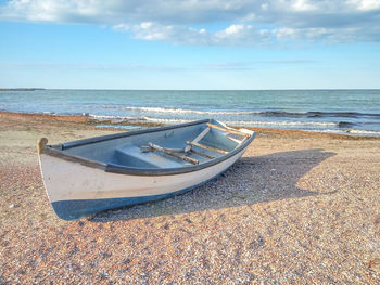 Empty boat on beach during sunny day