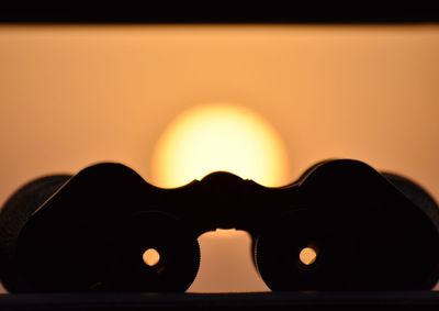 Close-up of illuminated silhouette against sky during sunset