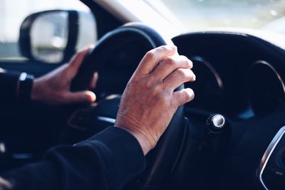 Cropped hands of person driving car