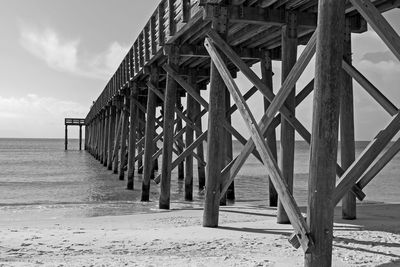 Pier on beach against sky