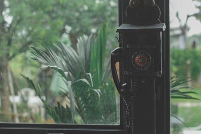 Close-up of camera seen through window