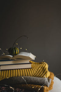 Still life of books, warm clothes and a pumpkin