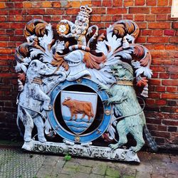 Statue against brick wall