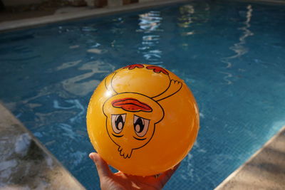 Close-up of person holding ball at swimming pool