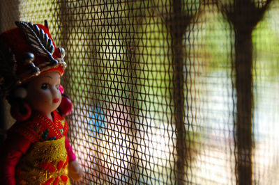 Close-up of doll by window at home