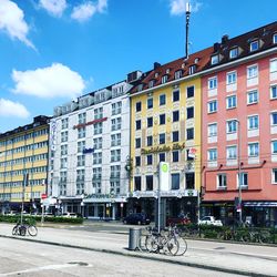 Buildings by road against sky in city