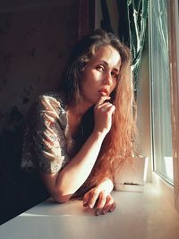 Portrait of young woman sitting on floor at home