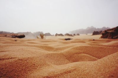 Surface level of sand at desert against clear sky