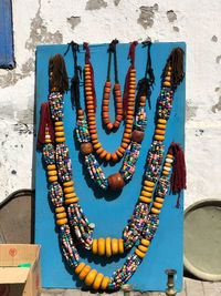 Close-up of multi colored jewelry for sale against wall 