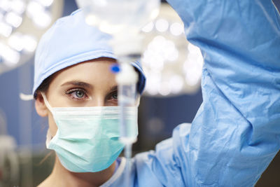 Female doctor looking iv drip in emergency room