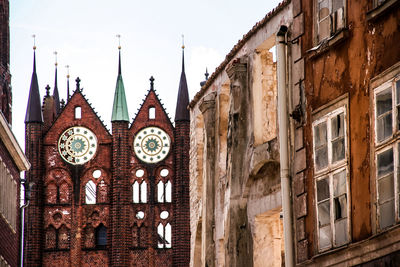 Low angle view of clock tower amidst buildings in city