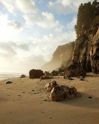 Rocks on beach against sky