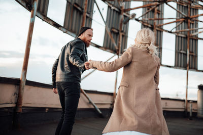 Side view of man standing on railing