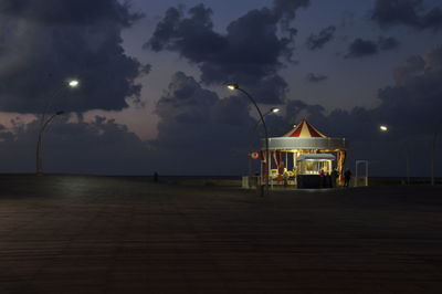 View of illuminated street light against cloudy sky