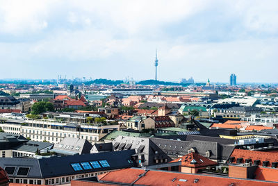 Residential district with fernsehturm in background against cloudy sky