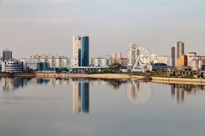 Reflection of buildings in lake against sky