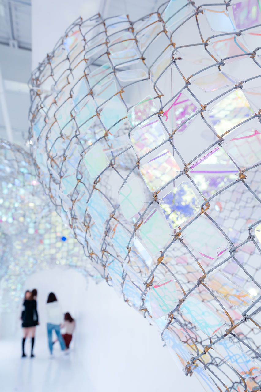 LOW ANGLE VIEW OF PEOPLE WALKING THROUGH GLASS