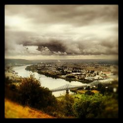 View of cityscape against cloudy sky