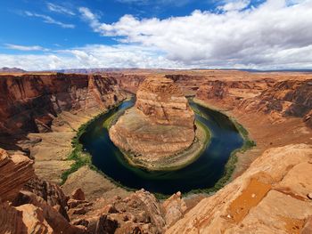 Scenic view of rock formations against cloudy sky