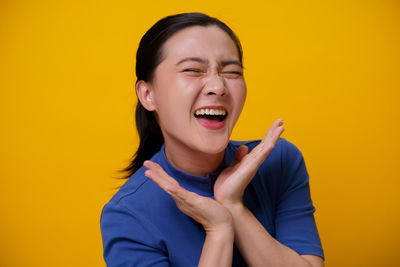 Portrait of a serious young man against yellow background