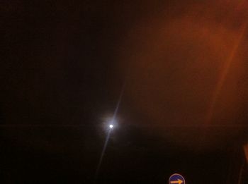 Low angle view of illuminated street light against sky