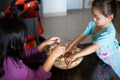 High angle view of kids in the kitchen, making cakes together.