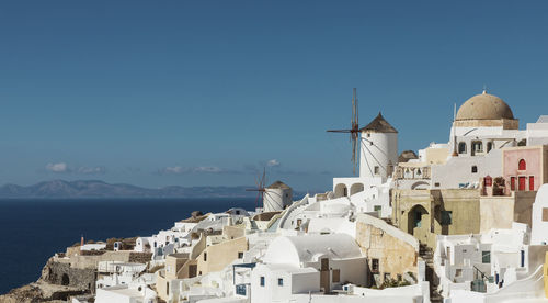 Buildings by sea against sky in city