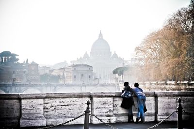 People standing in city against clear sky