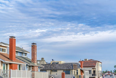 Low angle view of buildings against cloudy sky